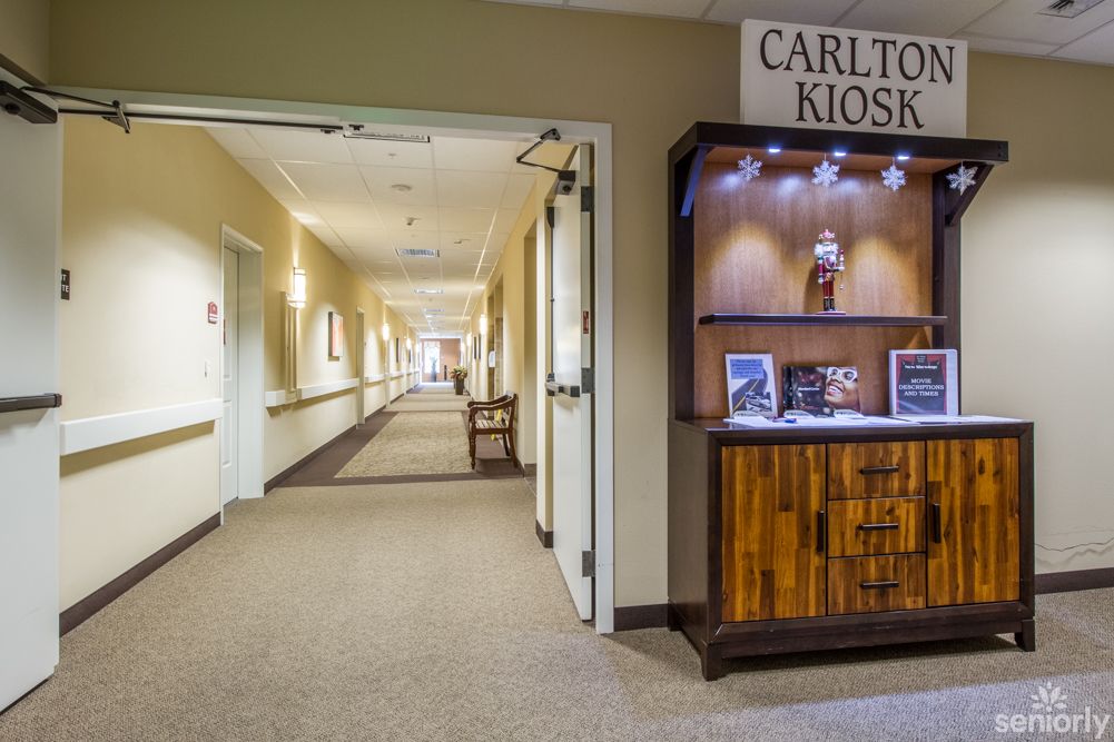 A well-lit interior hallway featuring a kiosk display labeled 'Carlton Kiosk'.