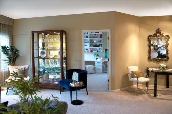 A modern living room interior featuring a display cabinet, a bookshelf, and stylish seating.