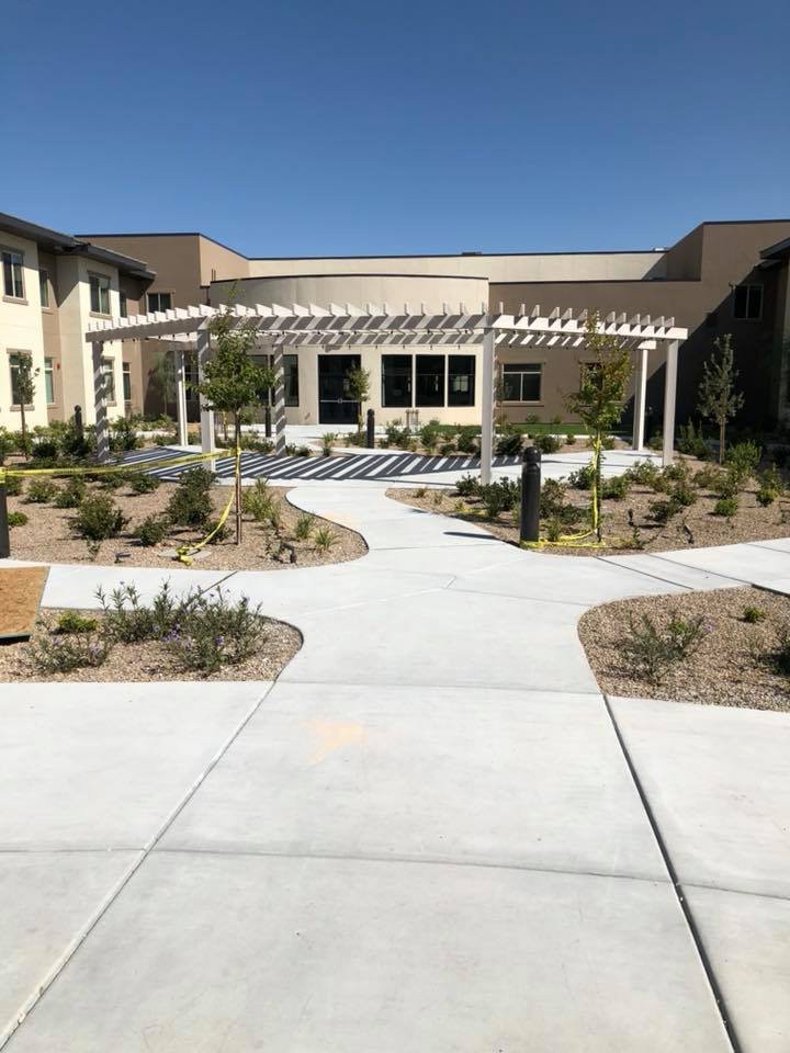 A landscaped courtyard with pathways and a modern building in the background.