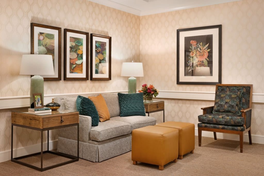 A cozy living room featuring a comfortable sofa, decorative pillows, wall art, and warm lighting.
