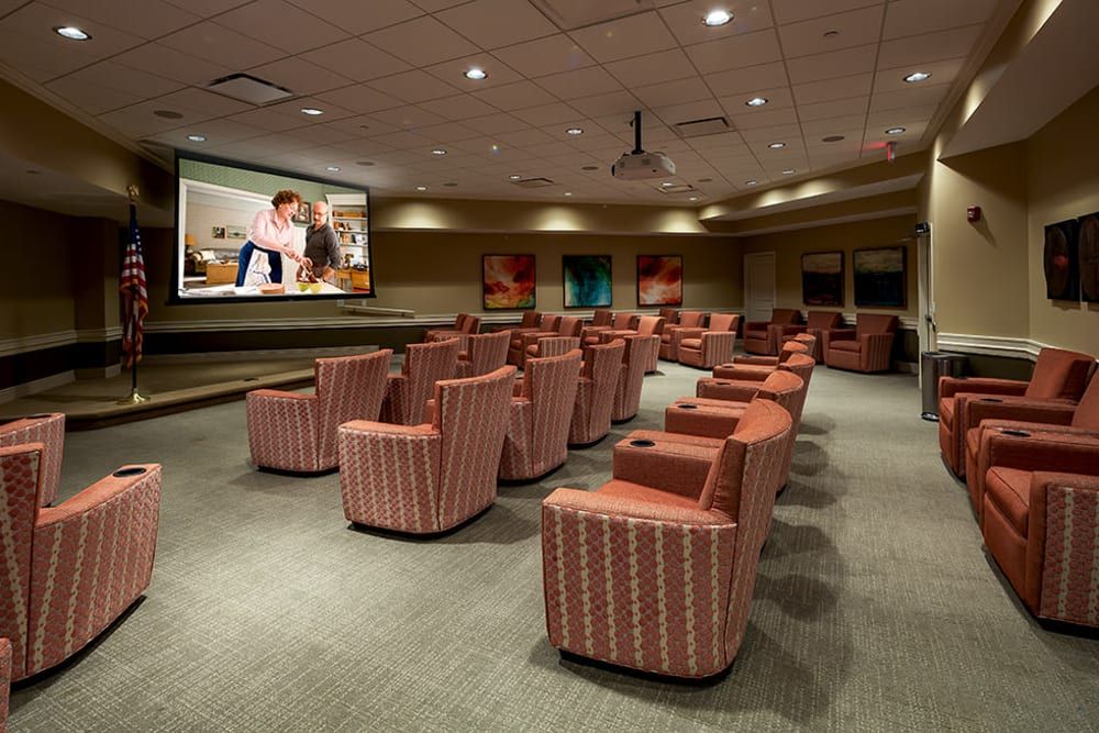 A cozy cinema room filled with comfortable chairs facing a large screen.