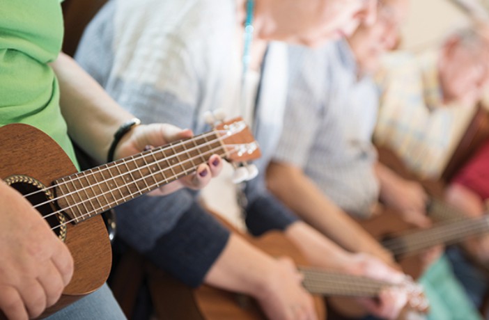 A group of people playing ukuleles together.