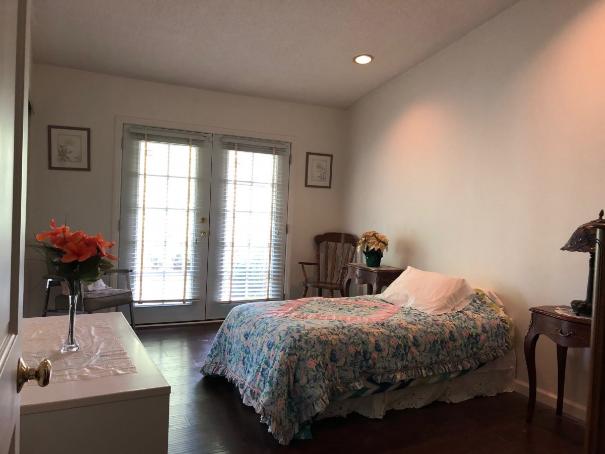A minimalist bedroom with a bed, decor, and large windows.
