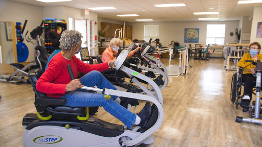 Seniors engaging in exercise routines on specialized equipment in a rehabilitation center.