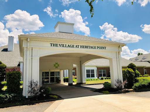 The entrance to The Village at Heritage Point, showcasing a welcoming architectural design under a clear blue sky.