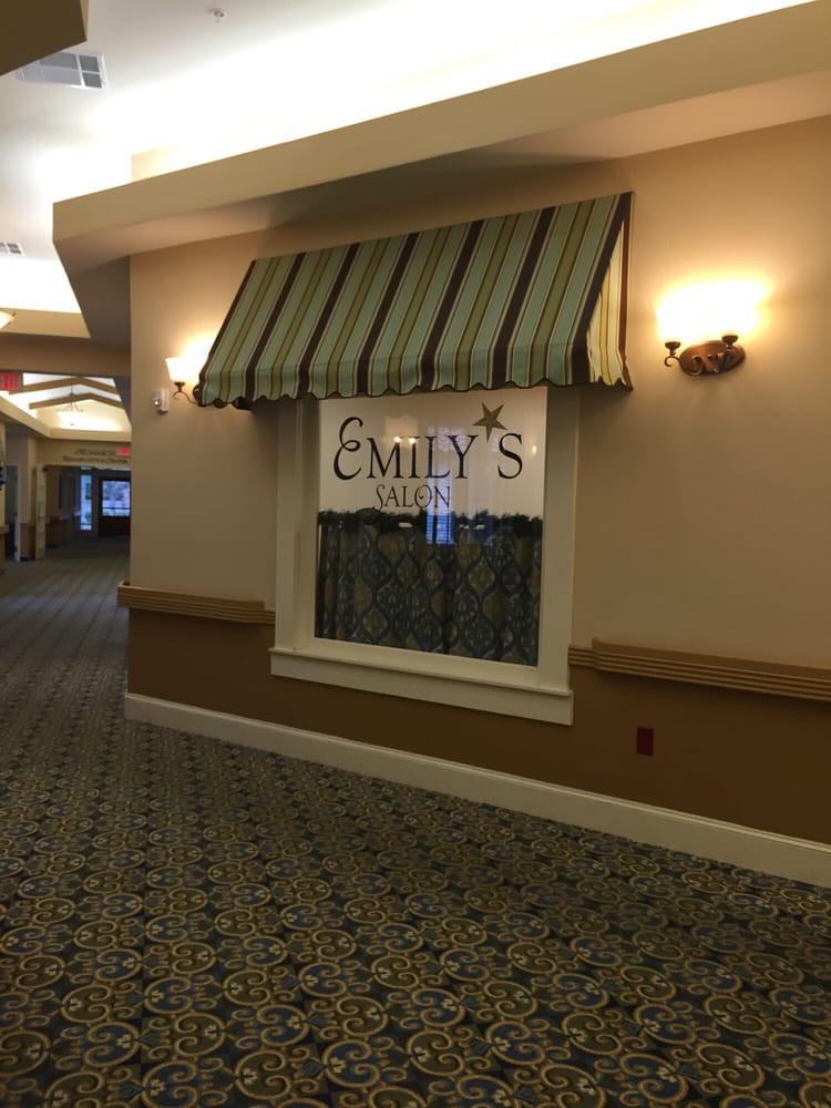 A hallway with a window displaying a sign for 'Emily's' under a striped awning.