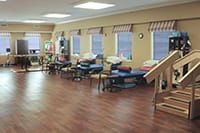 A rehabilitation clinic with therapy beds and exercise equipment.