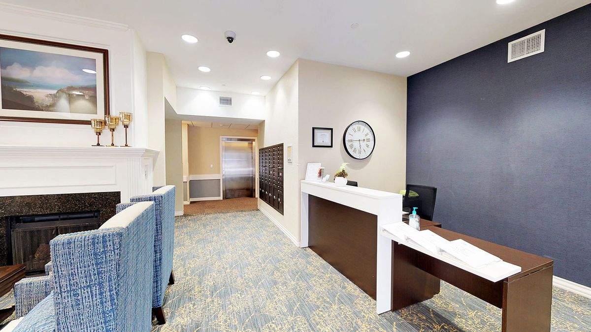 A modern office reception area with a desk and hallway.