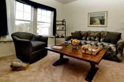 Cozy living room with a sofa, armchair, and coffee table.