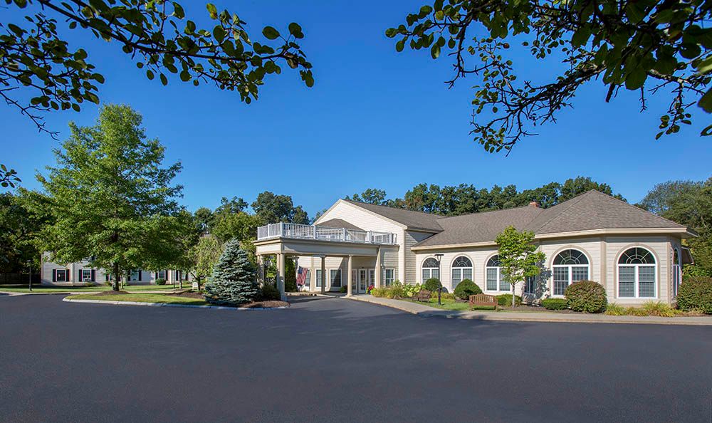 A residential building surrounded by trees under a clear blue sky.