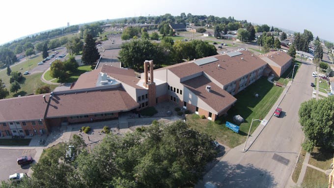 Aerial view of a school building surrounded by trees.