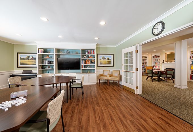 A cozy meeting room with bookshelves and a television.
