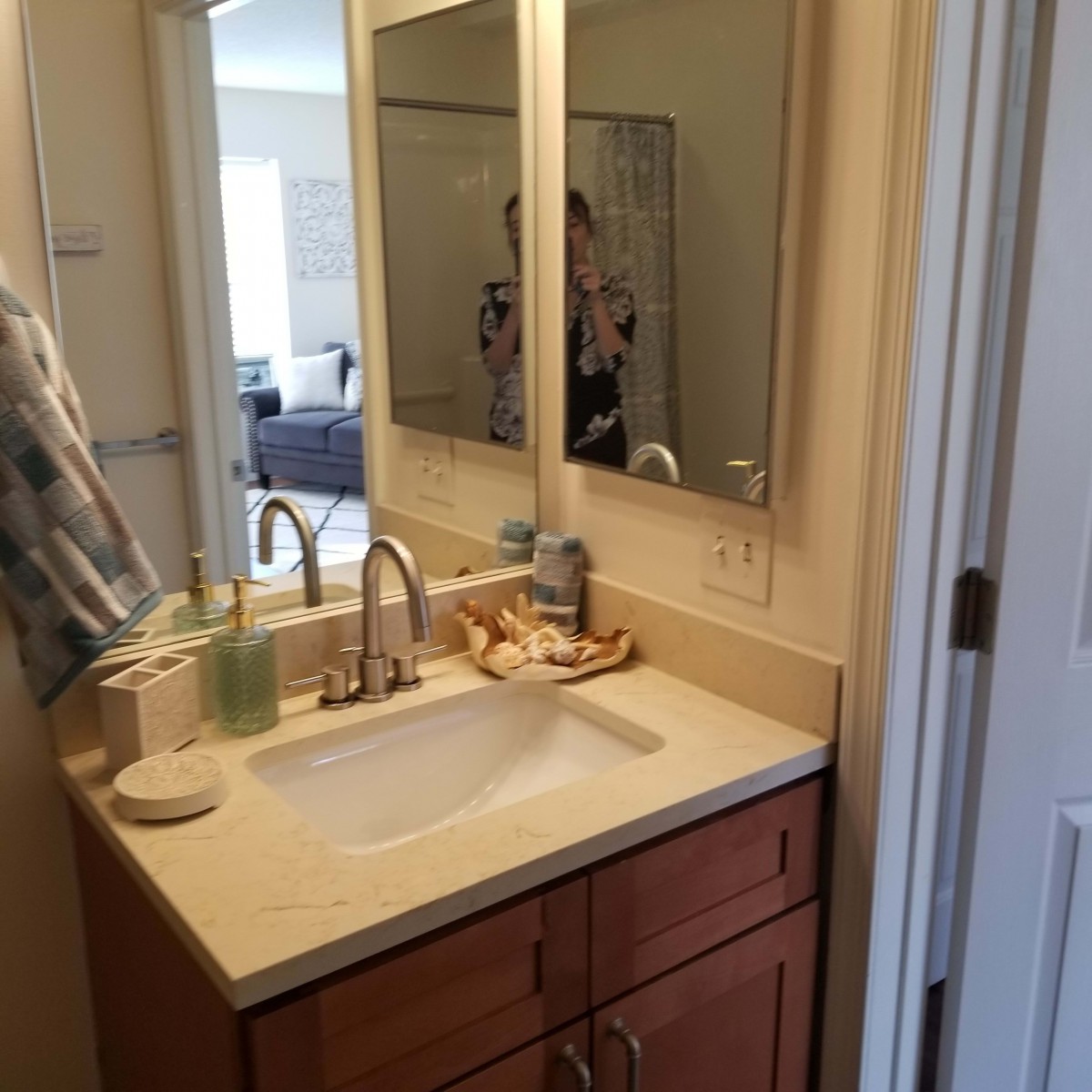 A tidy bathroom sink area with a mirror and neatly arranged items.
