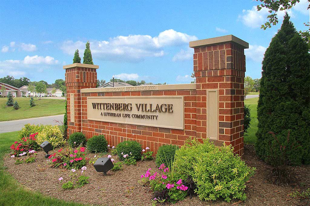 Entrance sign for Butterburg Village surrounded by landscaping.