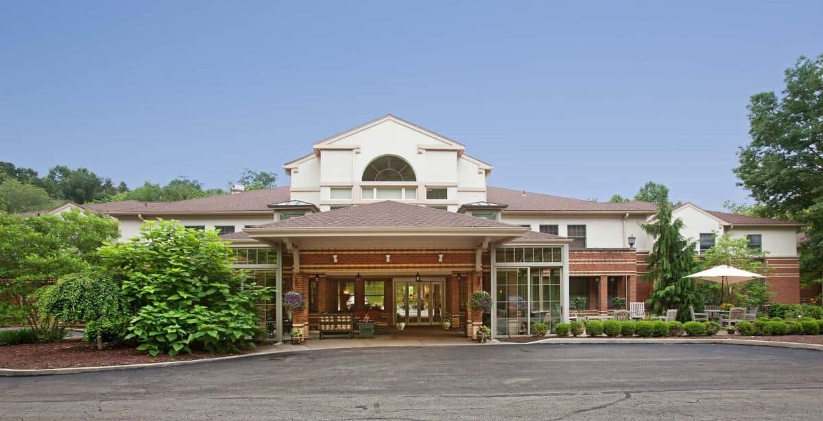 Front view of a hotel entrance with a clear sky backdrop.