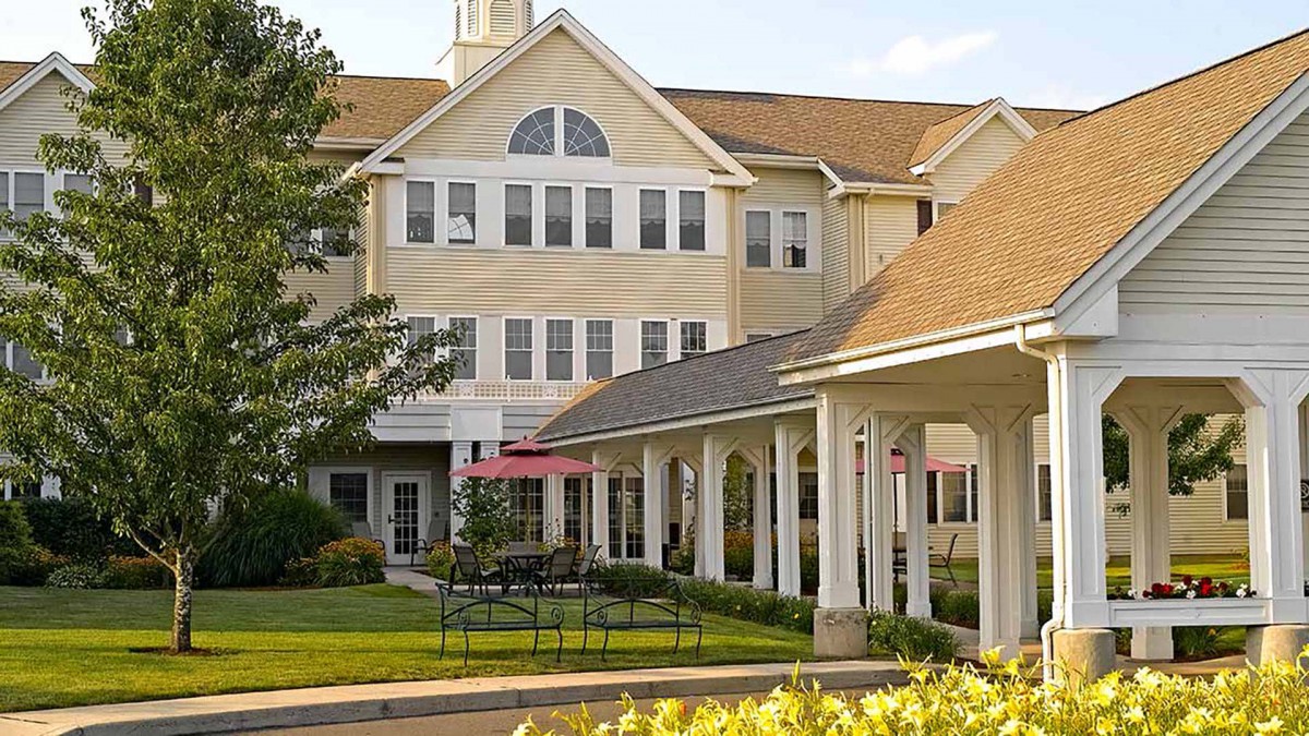 A large residential building with a well-maintained garden in the foreground.