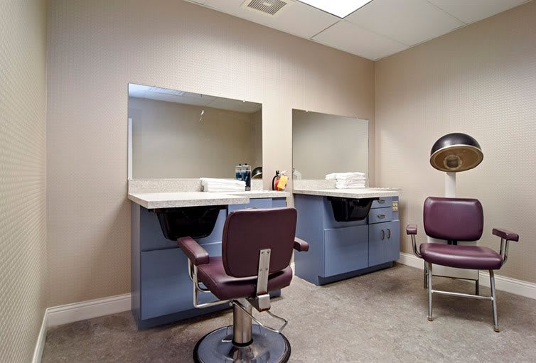 A tidy hair salon interior with two styling stations and comfortable chairs.