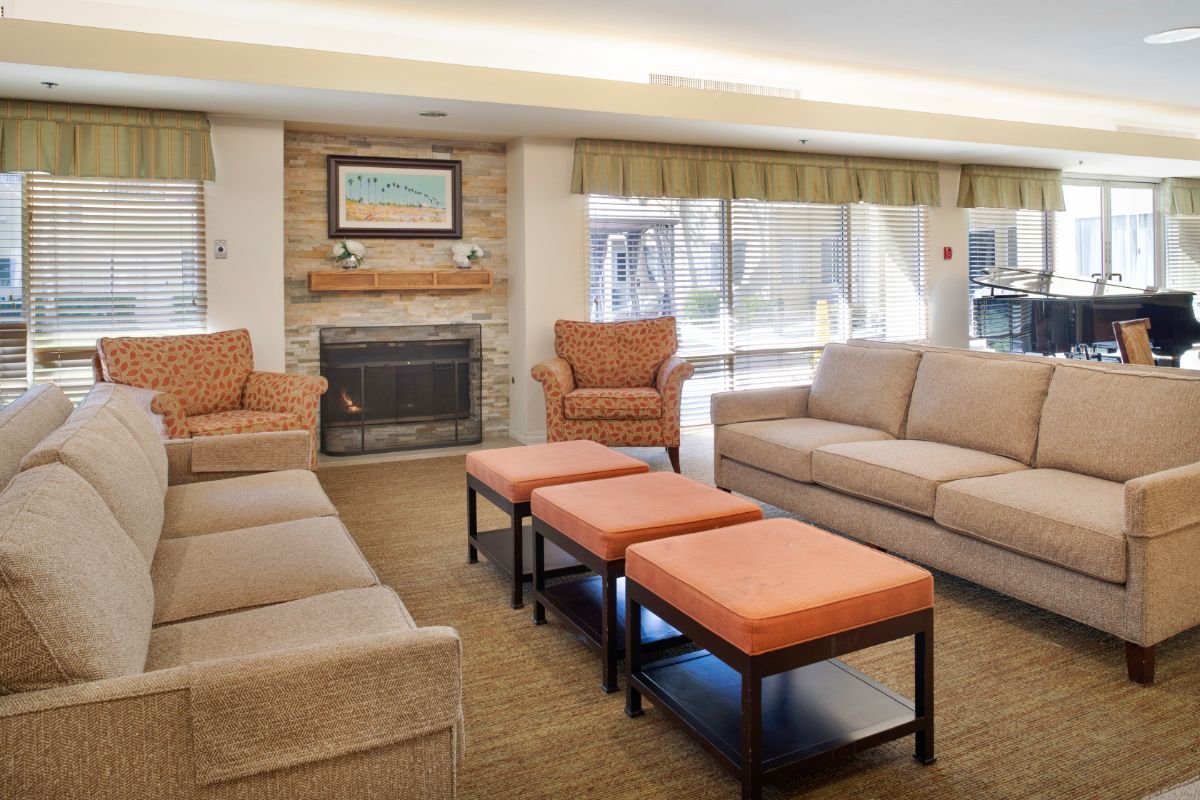 A cozy living room with sofas, armchairs, and a fireplace.