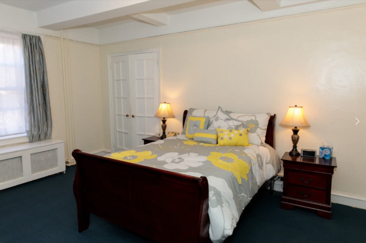 A cozy bedroom with a floral-patterned bedspread and warm lighting.