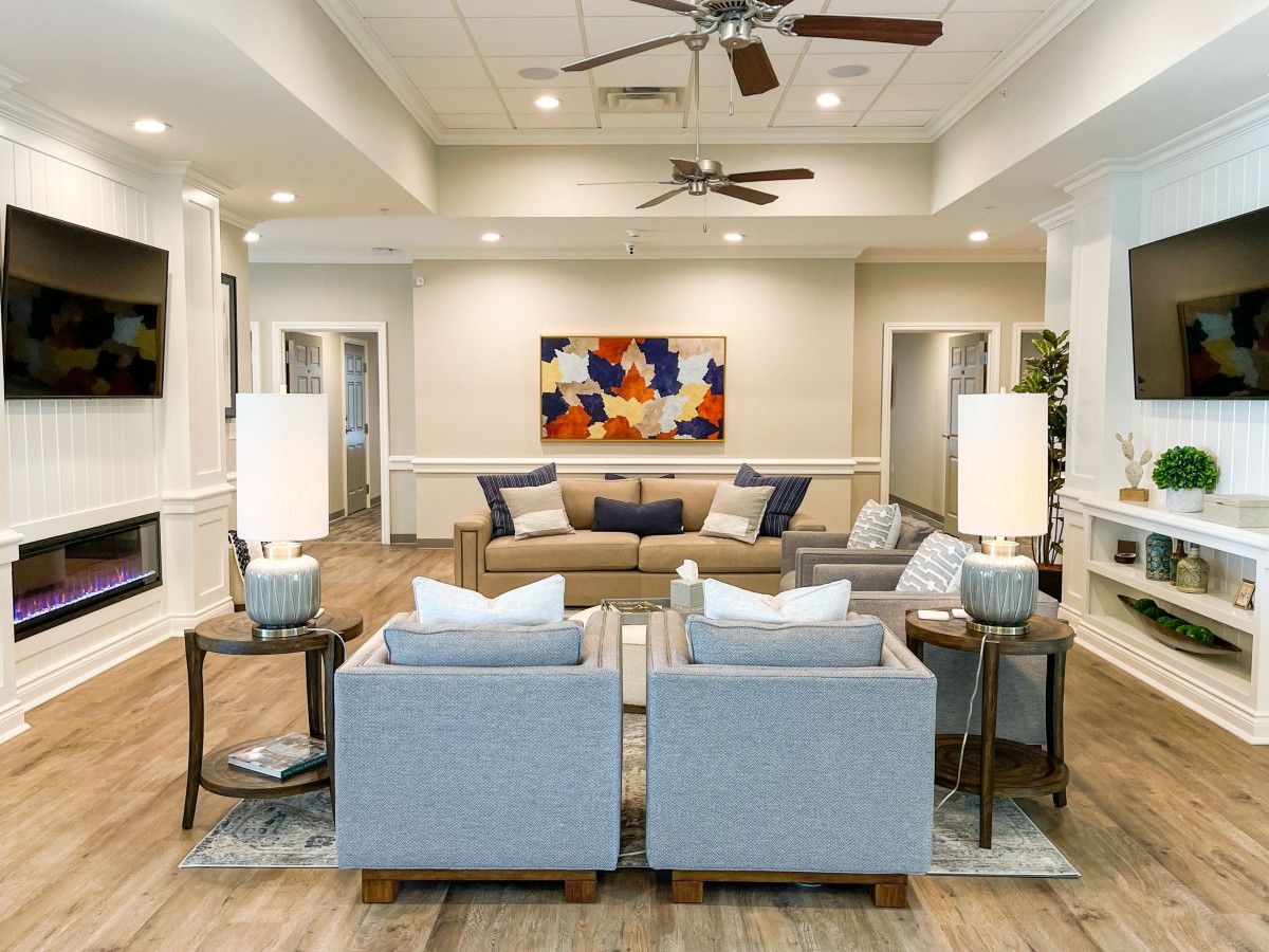 A modern living room with a comfortable seating area, vibrant artwork, and soft lighting.