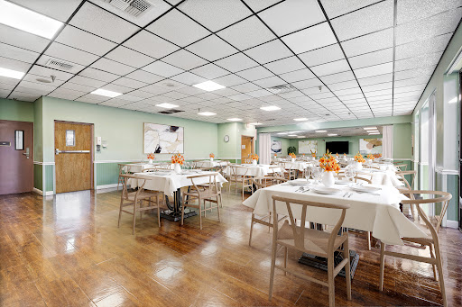 A spacious dining area set with neatly arranged tables and chairs, perfect for gatherings or meals.