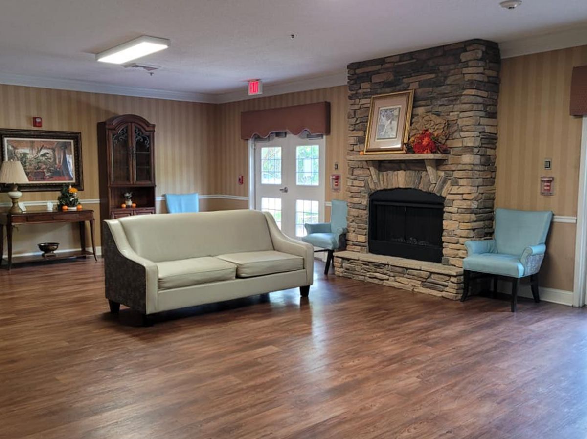 A cozy living room with a sofa and stone fireplace.
