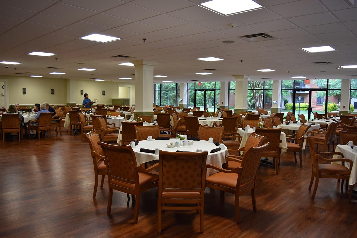 An empty dining room with neatly arranged tables and chairs.