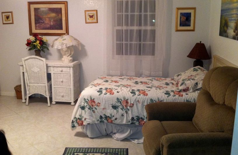 A cozy bedroom with a floral bedspread and a small nightstand.