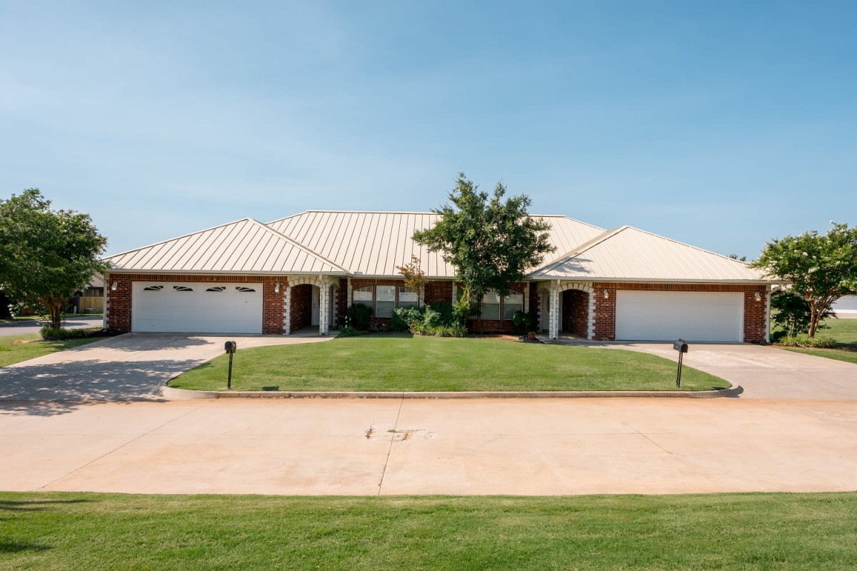 A suburban duplex with a manicured lawn and twin garages.