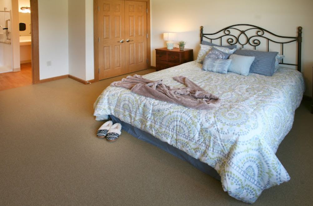 A cozy bedroom with a neatly made bed and soft lighting.