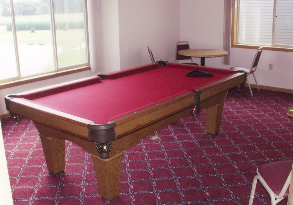 A game room featuring a pool table with red felt.