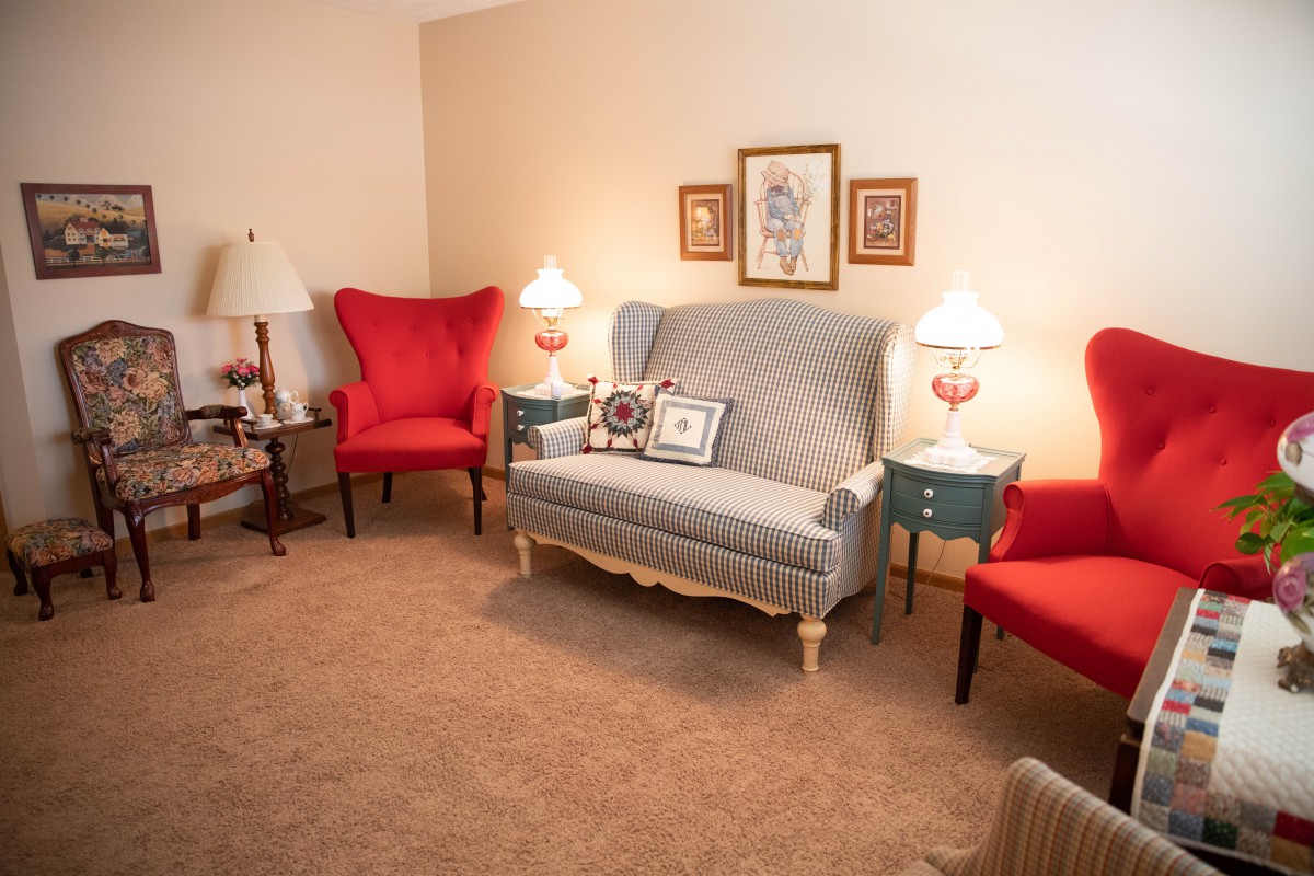 A cozy living room with a sofa, armchairs, and decorative lamps.
