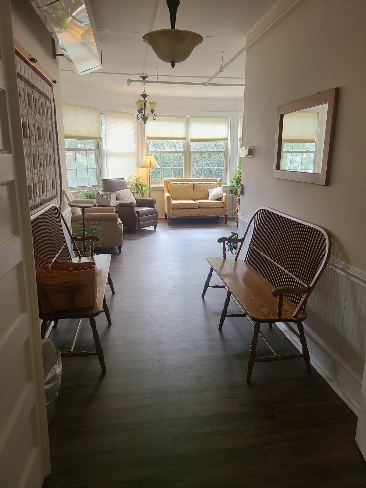 A cozy waiting area with benches and a sofa near large windows.