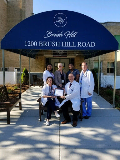 Medical team gathered outside Brush Hill facility, celebrating their achievements.