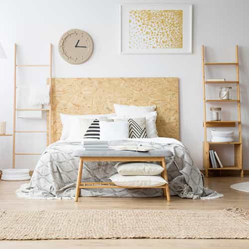A cozy bedroom with Scandinavian-style decor, featuring neutral colors and wooden furniture.