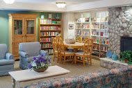 A cozy library room with bookshelves and comfortable seating.