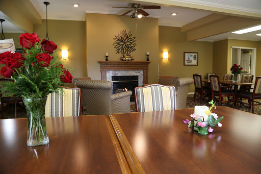 A warm and inviting living space with a stylish dining area, adorned with fresh flowers and a cozy fireplace.