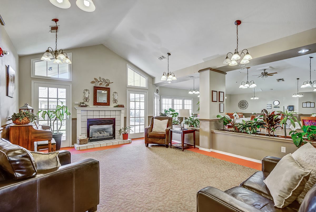 A spacious living room with a fireplace, comfortable seating, and large windows allowing natural light.