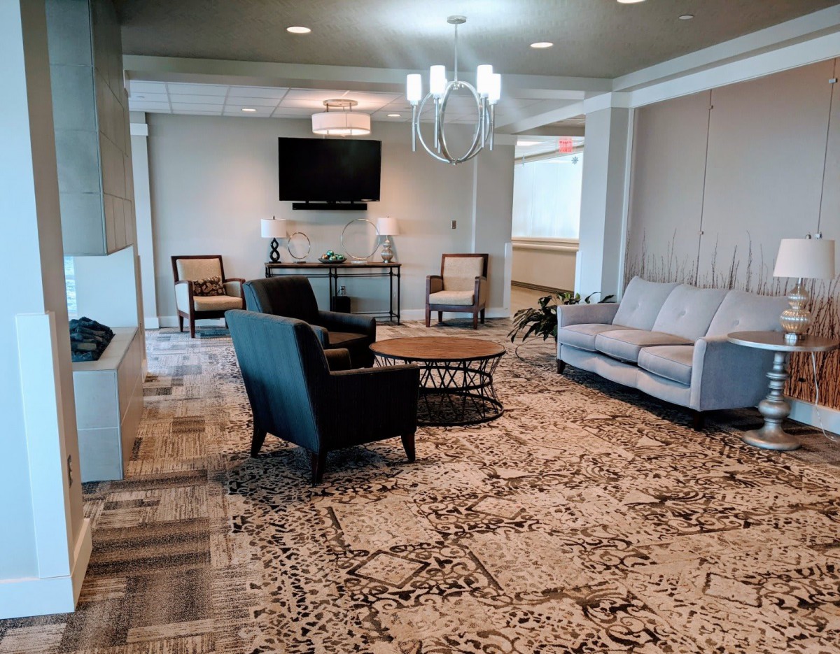 A modern living room with comfortable seating, a large carpet, and contemporary decor.