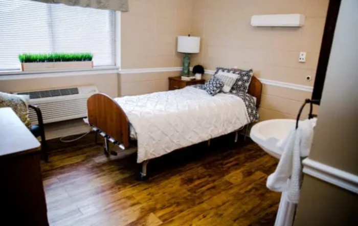 A cozy, simply decorated bedroom with a single bed and wooden flooring.