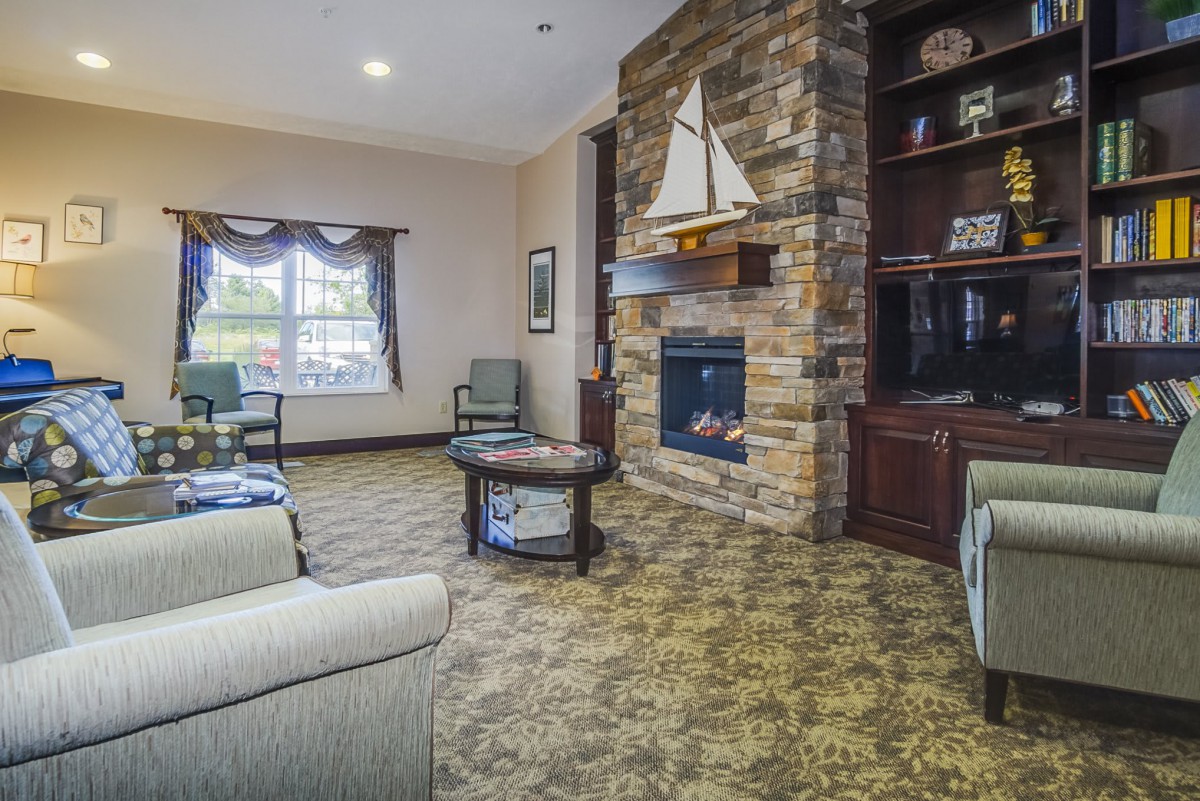 A cozy living room featuring a stone fireplace and sailing-themed decor.