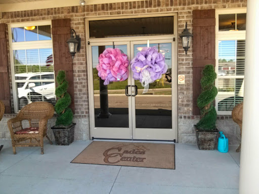 A charming storefront decorated with large flower arrangements and greenery.