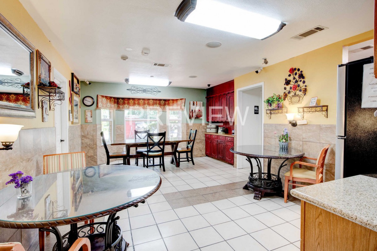 Spacious kitchen and dining area with tiled flooring and ample lighting.