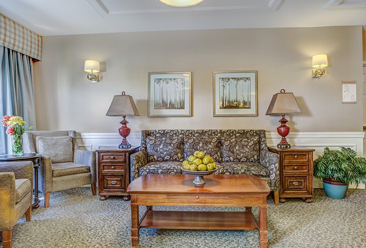 A cozy living room with a patterned sofa, wooden coffee table, and decorative lamps.