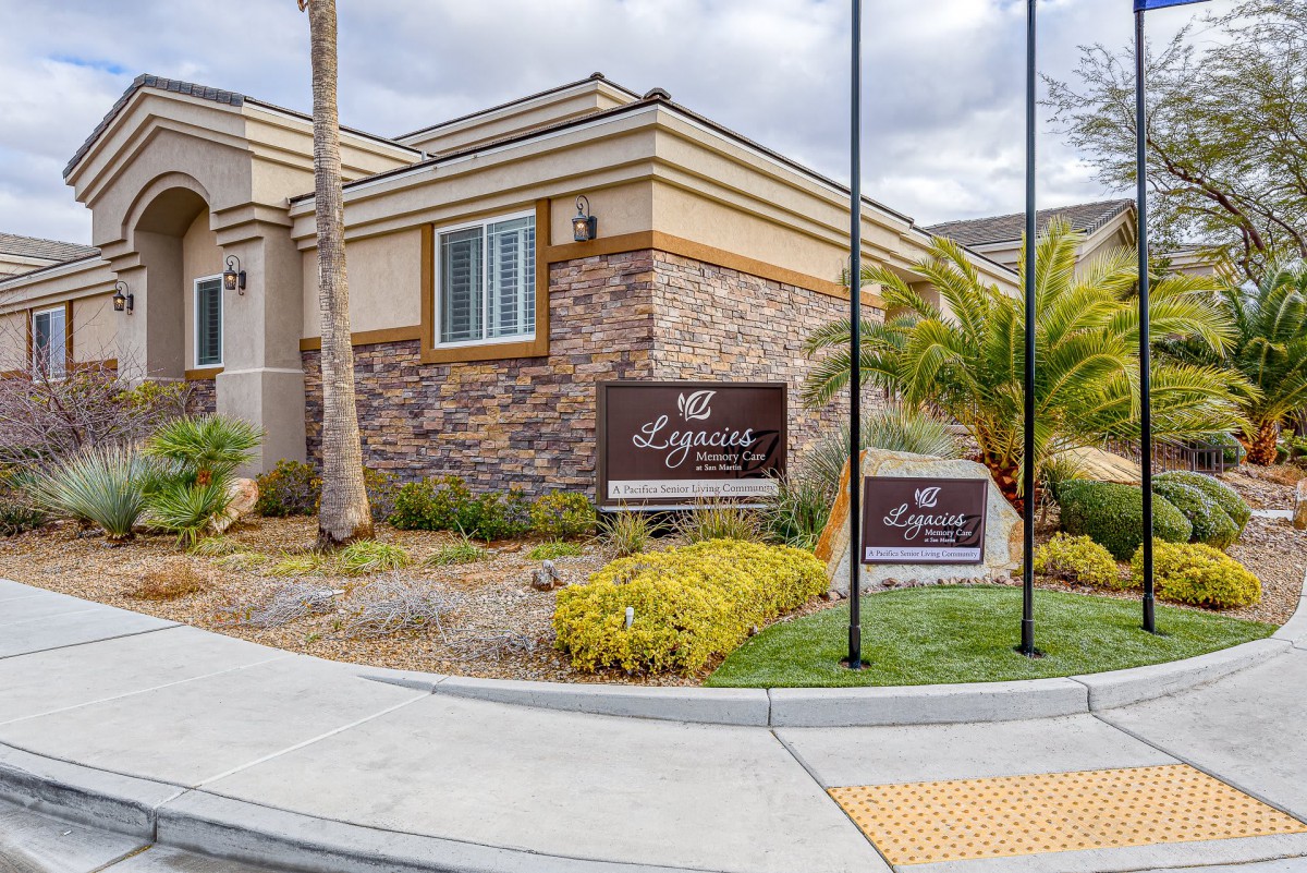 A residential building with well-maintained landscaping and signage.