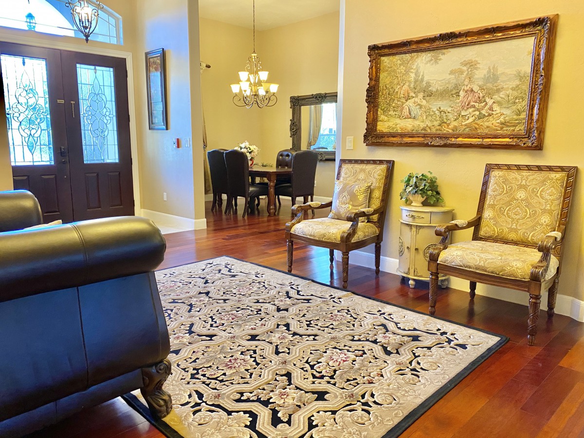 A cozy living room with elegant decor and a dining area in the background.