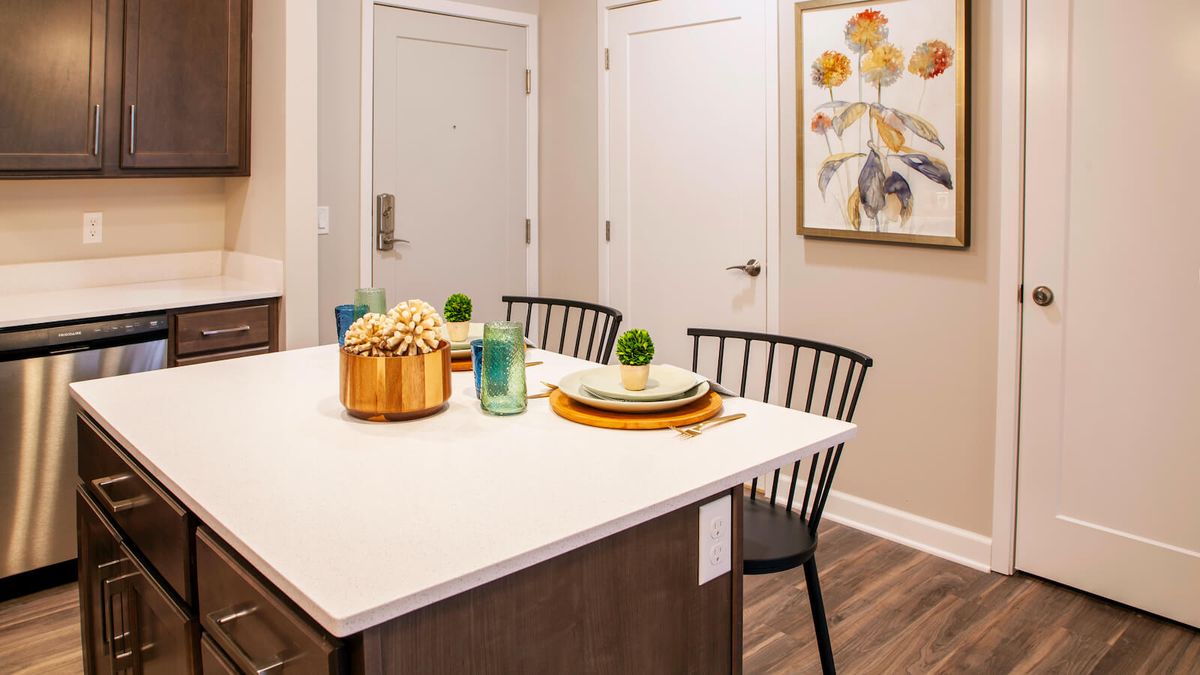 A modern kitchen island with a stylish table setting and artwork on the wall.