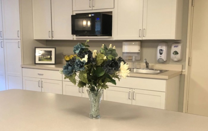A kitchen with a vase of colorful flowers on the countertop.