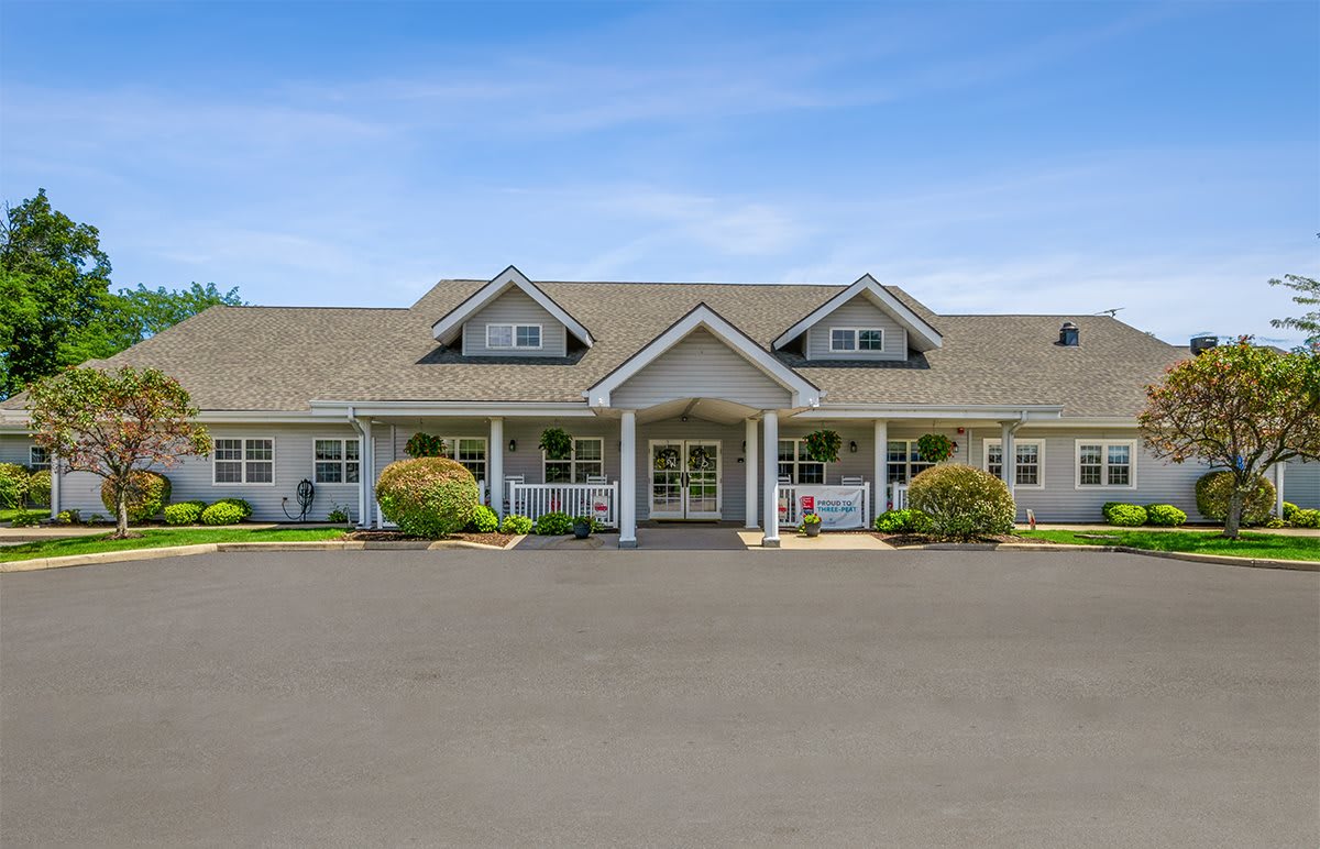 A charming single-story house with a large front porch and manicured landscaping.