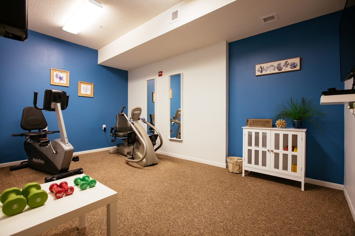 A home gym setup with exercise equipment and blue accent walls.